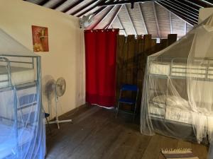 a room with two bunk beds and a red curtain at JackTavern - Auberge de Jeunesse in Pointe-Noire