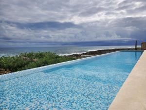 アクマルにあるRiviera Maya Luxury Oceanfront Condoの海の景色を望むスイミングプール