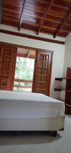 a bedroom with a large bed and a window at Casa dos Coqueiros Praia de Camburi, condomínio in Camburi +38 photos
