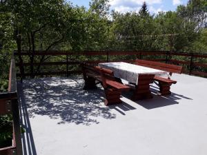 una mesa de picnic y dos bancos en un patio en Biljevina, en Saborsko