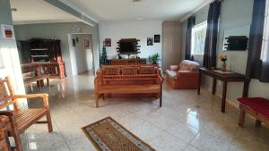 uma sala de estar com um sofá e uma televisão em Recanto das Pretinhas em Ibiúna