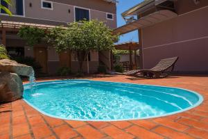 una pequeña piscina con una fuente de agua en un patio en Pousada Nanai, en Foz do Iguaçu