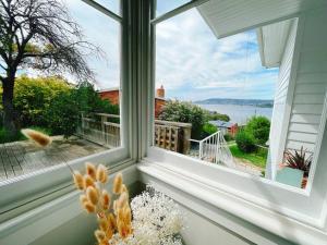 a window seat with a view of the water at Spectacular Hobart River View Home in Lindisfarne