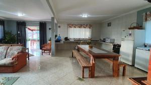 a kitchen with a table and a couch and a refrigerator at Recanto das Pretinhas in Ibiúna