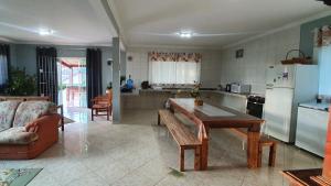 uma cozinha com uma mesa, um sofá e um frigorífico em Recanto das Pretinhas em Ibiúna