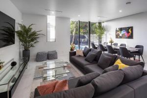 a living room with a large couch and a table at Coral Ridge Playtime - Gorgeous Private Pool Home Close To Everything! townhouse in Fort Lauderdale