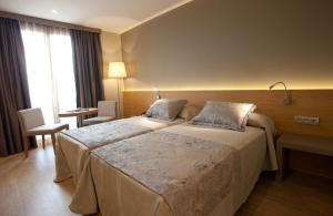 a hotel room with a bed and two nightstands at M.A. Hotel Sevilla Congresos in Seville