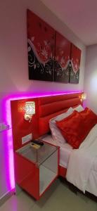 1 dormitorio con cama roja y mesa de cristal en Penang karaoke Ruby Townhouse 1st floor, en Bayan Lepas