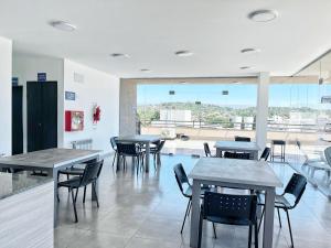 une salle à manger avec tables et chaises et une grande fenêtre dans l'établissement PASEO QUATTRO, à Villa Carlos Paz