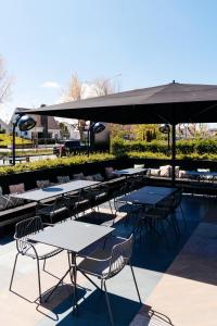a patio area with chairs, tables and umbrellas at ENSO - Boutique Hotel in Knokke-Heist