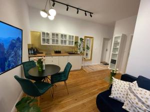 a living room with a table and a kitchen at Willa 1936 , Parking in Toruń