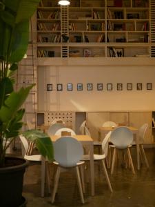 un tavolo con sedie in una stanza con scaffali di Imago Plus Hotel a Bari