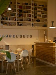 a dining room with white chairs and a table at Imago Plus Hotel in Bari