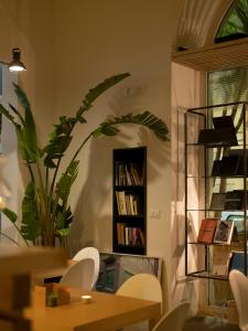 una stanza con un tavolo e una libreria con libri di Imago Plus Hotel a Bari