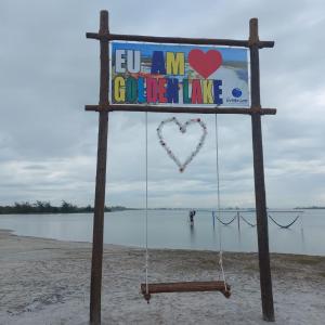 a sign on the beach with a heart sign at GOLDEN LAKE RESIDENCE ARRAIAL DO CABO in Arraial do Cabo