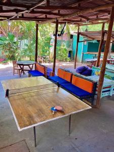 a wooden table and chairs under a pavilion at Coral Reef Surf Hostel and Camp in Tamarindo