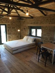 a bedroom with a large bed in a brick wall at Lemnian house in Portiano in Pedhinón