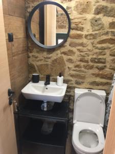 a bathroom with a sink and a toilet and a mirror at Lemnian house in Portiano in Pedhinón