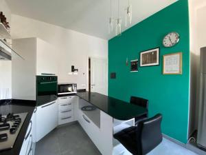 a kitchen with a green accent wall at La casa di Betty in Salsomaggiore Terme +1 photo