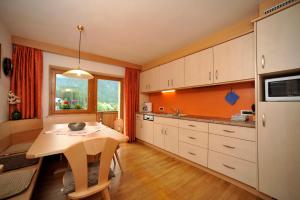 a kitchen with a table and a dining room at Penthouse-Apartment Limbela in Ortisei