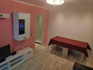 ein Wohnzimmer mit einem Tisch und einem TV in der Unterkunft VA Apartments in Rēzekne