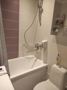 een badkamer met een wit toilet en een douche bij VA Apartments in Rēzekne