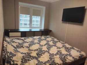 a bedroom with a bed with a television and a window at VA Apartments in Rēzekne