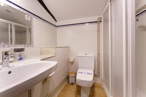 a white bathroom with a sink and a toilet at Casa Brandariz in Santa Maria de Arzua