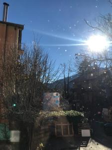 uma vista da cidade a partir de uma janela com o sol a brilhar em Agréable Studio dans le village em Saint-Martin-Vésubie