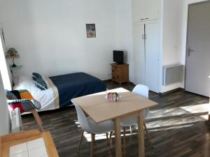 um quarto com uma cama, uma mesa e cadeiras em Agréable Studio dans le village em Saint-Martin-Vésubie