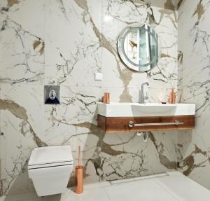 a bathroom with a white toilet and a sink at Premium Luxury SeaSide Apartment in Burgas City +16 photos