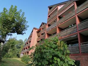 een appartementencomplex met een struik ervoor bij Haus Schwarzwaldgrund in Baiersbronn