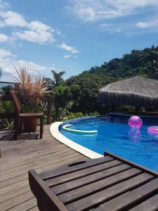 uma piscina com um deque de madeira e um resort em Pousada Sunshine Beach em Angra dos Reis