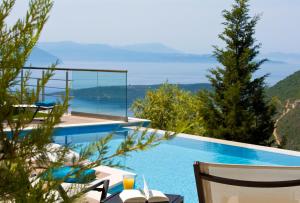 een zwembad met uitzicht op het water bij Heavenly Heights Villas in Évyiros