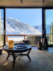 a table and chairs in front of a large window at Langley Hôtel Tignes 2100 in Tignes