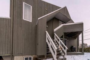 una casa con una escalera en el lateral de ella en INITIAL - LE REPOS DES SKIEURS - Mont-Sainte-Anne, en Saint-Férréol-les-Neiges