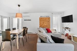 ein Wohnzimmer mit einem Sofa und einem Tisch in der Unterkunft INITIAL - LE REPOS DES SKIEURS - Mont-Sainte-Anne in Saint-Férréol-les-Neiges