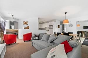 Saint-Férréol-les-Neiges的住宿－INITIAL - LE REPOS DES SKIEURS - Mont-Sainte-Anne，客厅配有灰色的沙发和红色的椅子