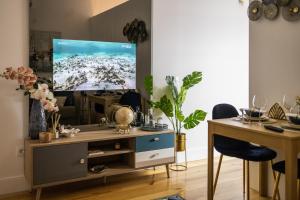 a living room with a tv and a table and a desk at THE TWIN Apartments in Porto