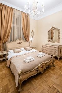 ein Schlafzimmer mit einem großen Bett und einem Spiegel in der Unterkunft 3 bedrooms Royal Italian style in an Austrian building, parking, balcony in Lwiw