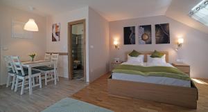 a bedroom with a bed and a table and a dining room at Fenyves Apartmanok in Balatonfenyves