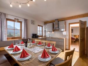 ein Esszimmer mit einem Tisch mit roten Servietten darauf in der Unterkunft Franbichl in Brixen im Thale