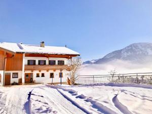 una casa cubierta de nieve con montañas en el fondo en Franbichl en Brixen im Thale