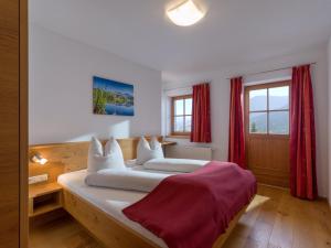 1 dormitorio con 1 cama grande y cortinas rojas en Franbichl en Brixen im Thale