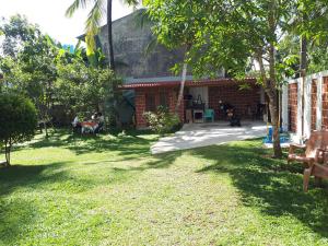 a yard of a house with people sitting at My Home Resort in Matara +19 photos