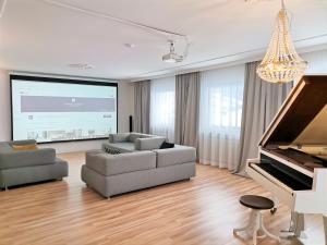 uma sala de estar com um sofá e um piano em Rafael Kaiser Residence Privée - Spielberg Obdach em Obdach