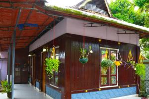 a small house with potted plants hanging from it at Royal Holidays in Alleppey +13 photos
