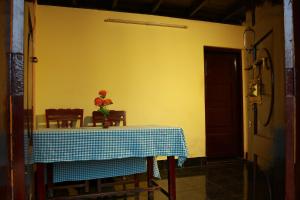 a table in a room with a vase of flowers on it at Royal Holidays in Alleppey