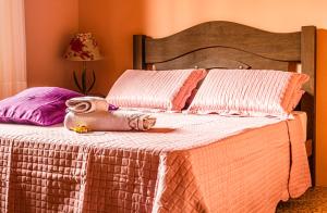 a bed with a blanket and towels on it at Pousada Casa do Oscar in Governador Celso Ramos