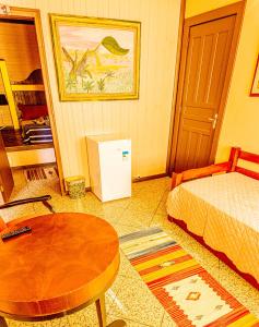 a small room with a bed and a table and a table sidx sidx at Pousada Casa do Oscar in Governador Celso Ramos
